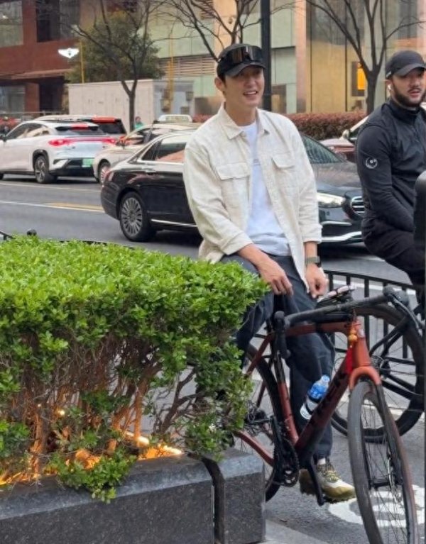 33岁黄景瑜在上海路边骑单车被偶遇, 他穿着白衬衫, 面带笑容好帅
